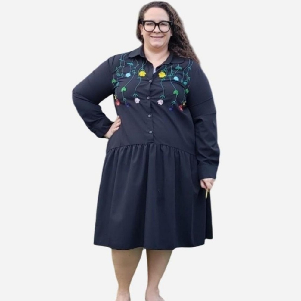 A black, shirt dress with embroidered multi-colored flowers.